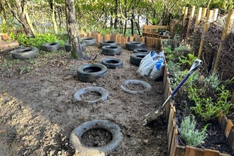 A garden with raised beds and stepping stones made from old tyres